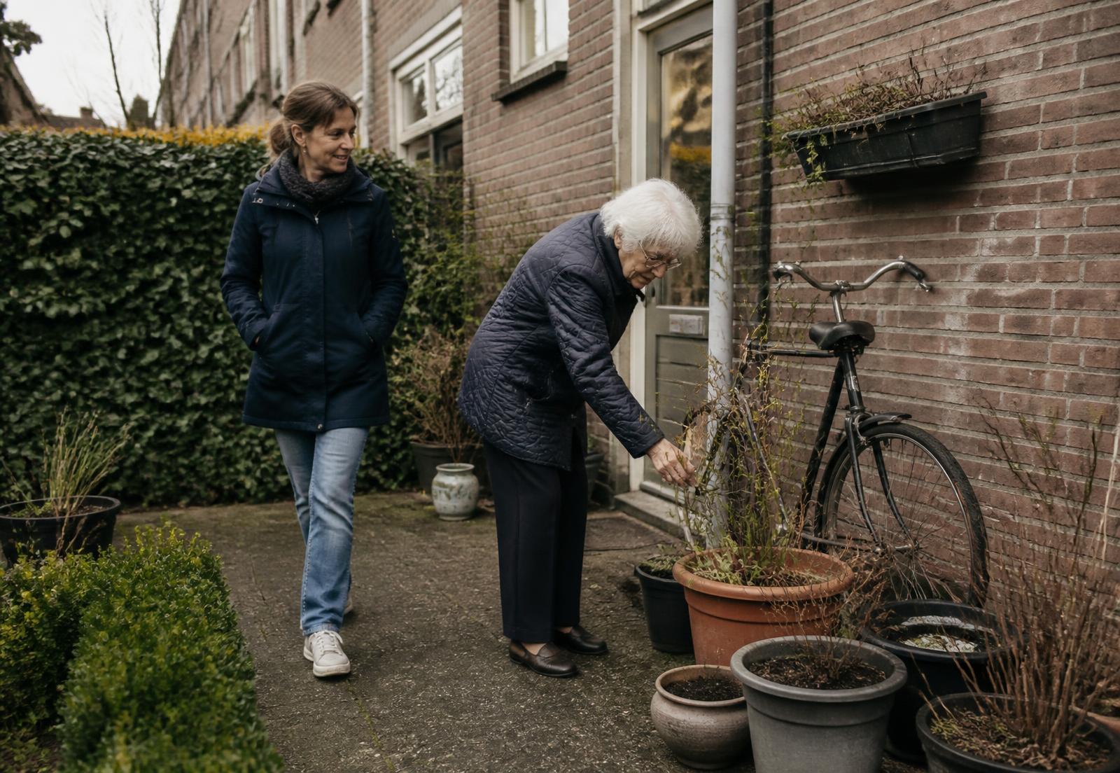 Oudere vrouw in haar eigen tuin, samen met een naaste
